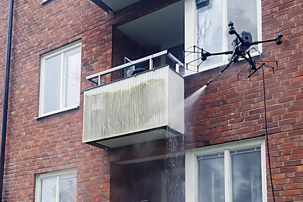 Drönare som används för att tvätta balkonger på ett bostadshus.