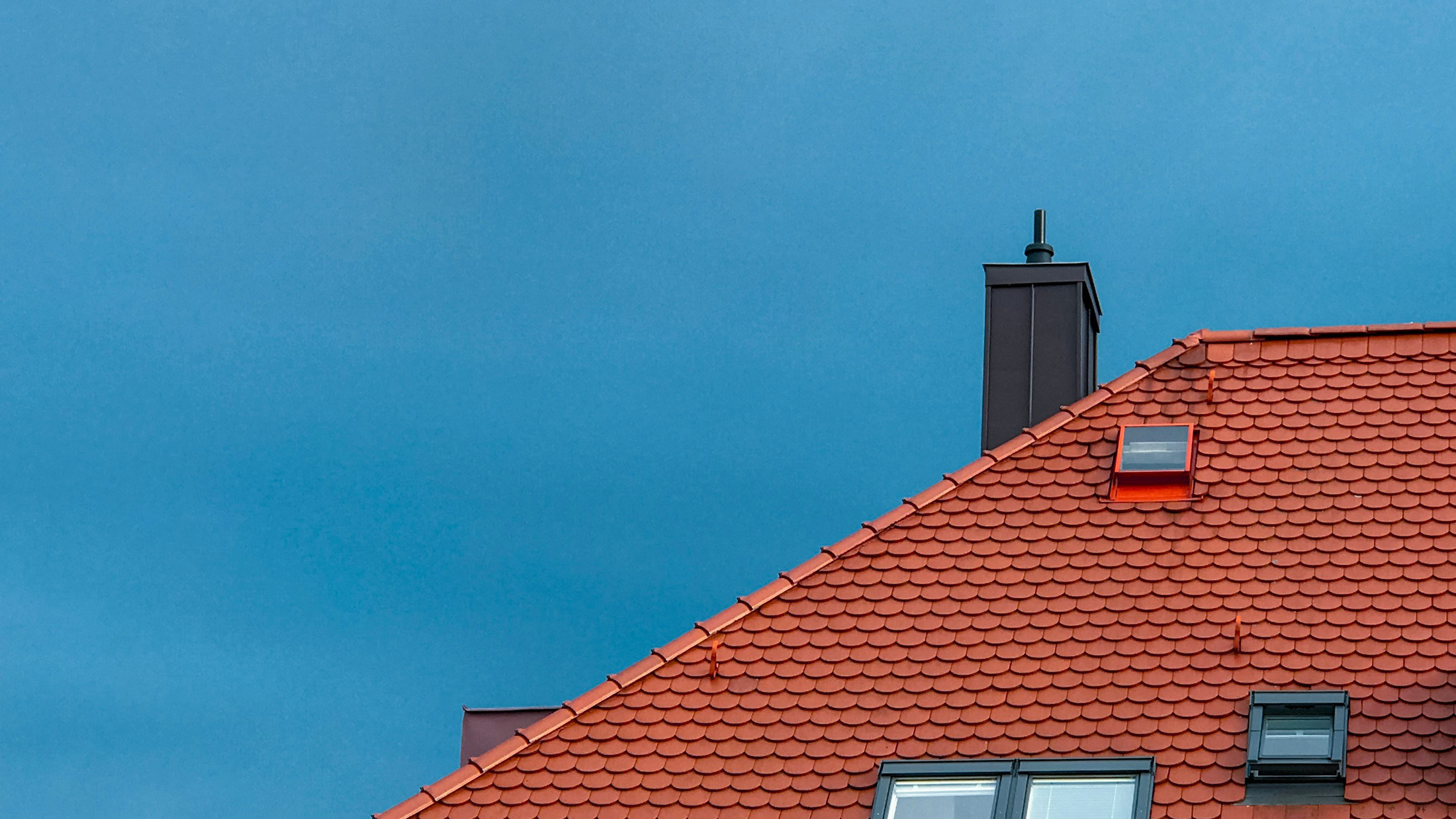 Ett tak på ett bostadshus som blivit rengjord med drönartvätt.
